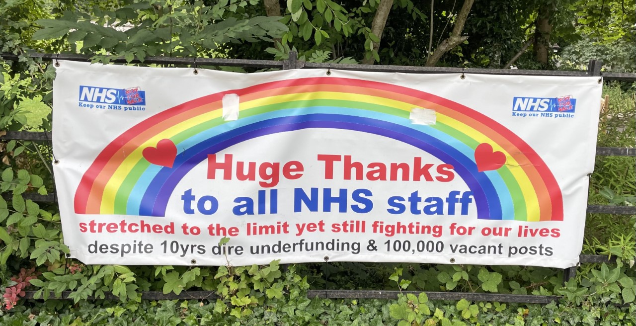 Rainbow banner thanking all NHS staff, while making political points about inadequate NHS funding and strains on staff.